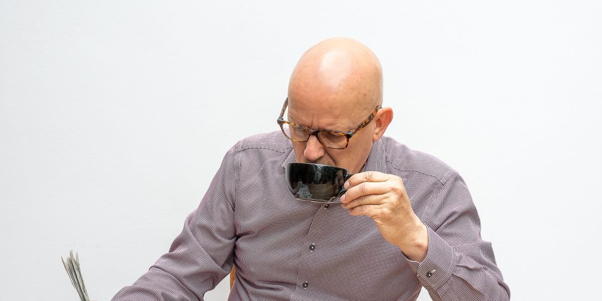 A person reads news on a tablet or phone, appearing thoughtful or unsure, reflecting the low trust in media.