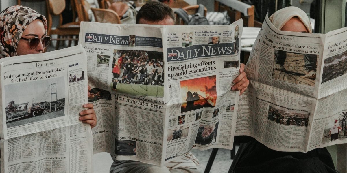 A diverse group of people engaging with local news in their community, reflecting its broad appeal and trusted role.