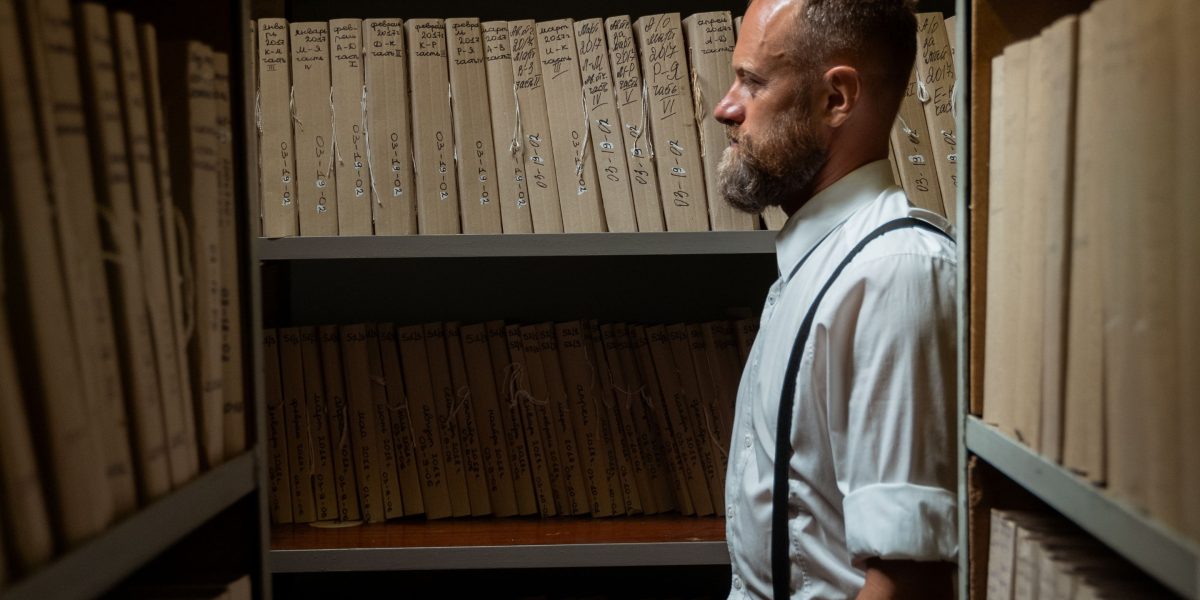 A researcher reviewing historical documents, illustrating the use of newspapers as primary sources.