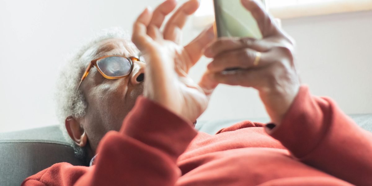 A person looking concerned while reading news on a tablet, symbolizing the risk to brand reputation when ads appear next to untrustworthy content.