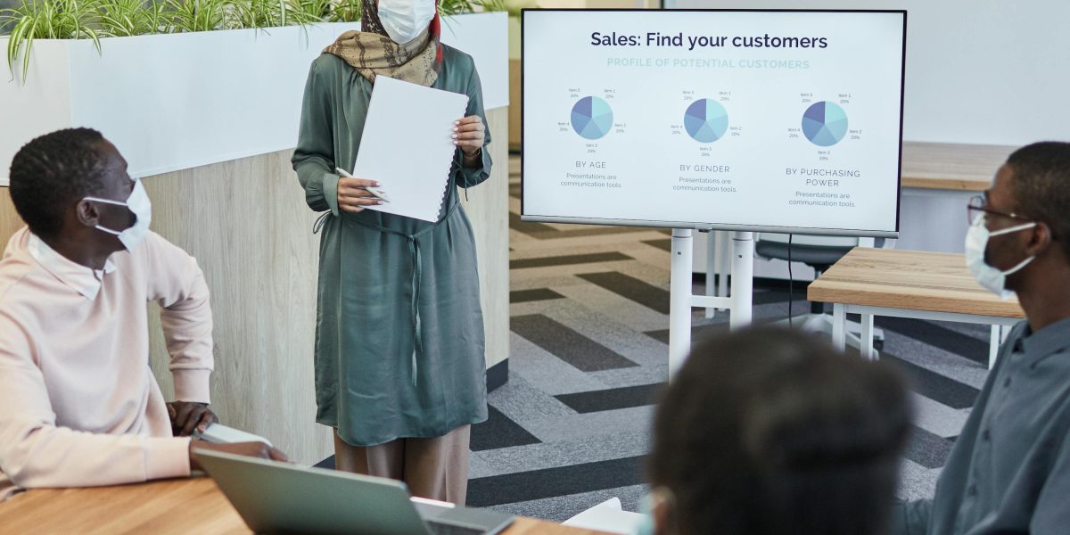 A professional presenting to a team, symbolizing the reporting and improvement phase of implementing brand safety strategies.