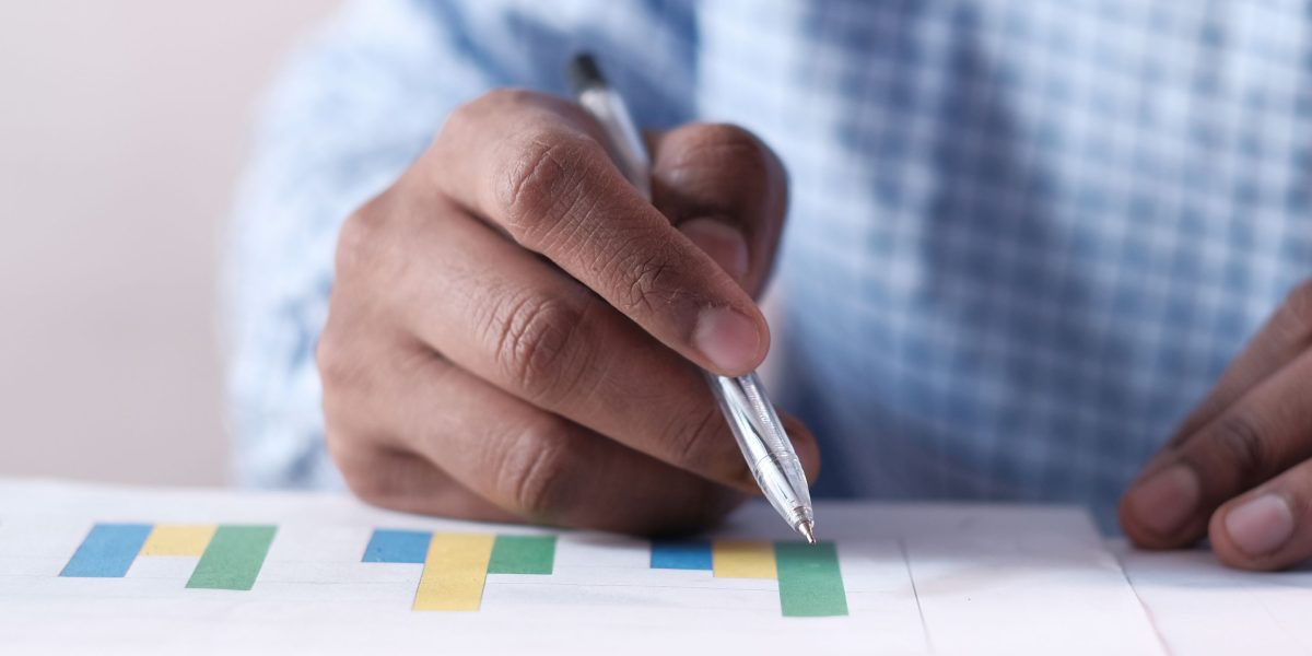 A person thoughtfully analyzing charts and data on reports, representing data-driven decision-making.