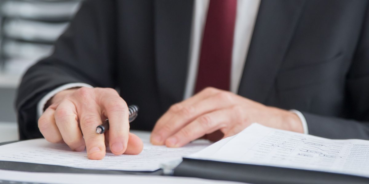 An advertising executive meticulously reviews reports to ensure ad placements align with brand safety.