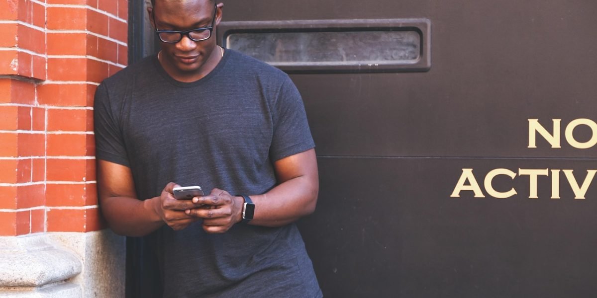 A person thoughtfully scrolling through news on their phone, searching for credible sources.