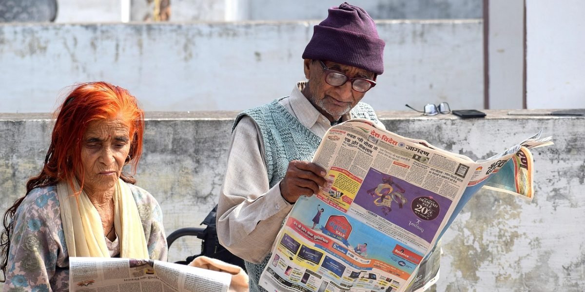 A person intently reading a physical newspaper, highlighting the enduring trust and engagement associated with print media.