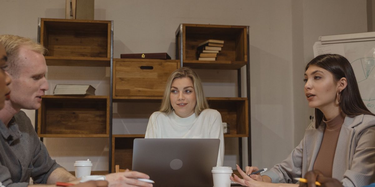 A group of professionals in a meeting, reviewing documents and discussing regulatory compliance.